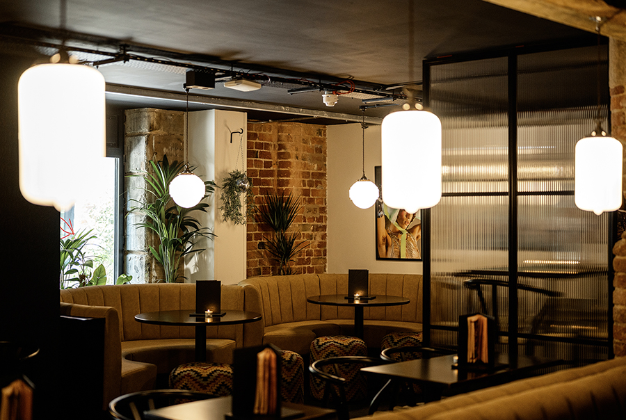 A lit bar setting tiled with onyx emerald polished porcelain wall tiles